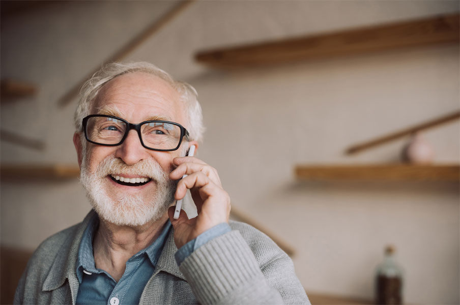 Senior telefoniert lachend mit einem Smartphone